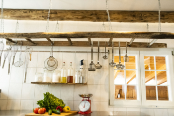a kitchen with a wooden ladder and utensils from the ceiling