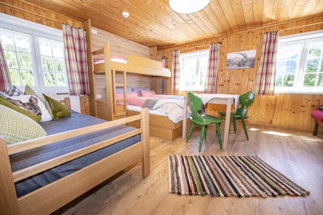 ein Zimmer mit Etagenbetten und Tisch